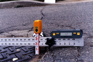Measuring equipment showing hole depth in roadway